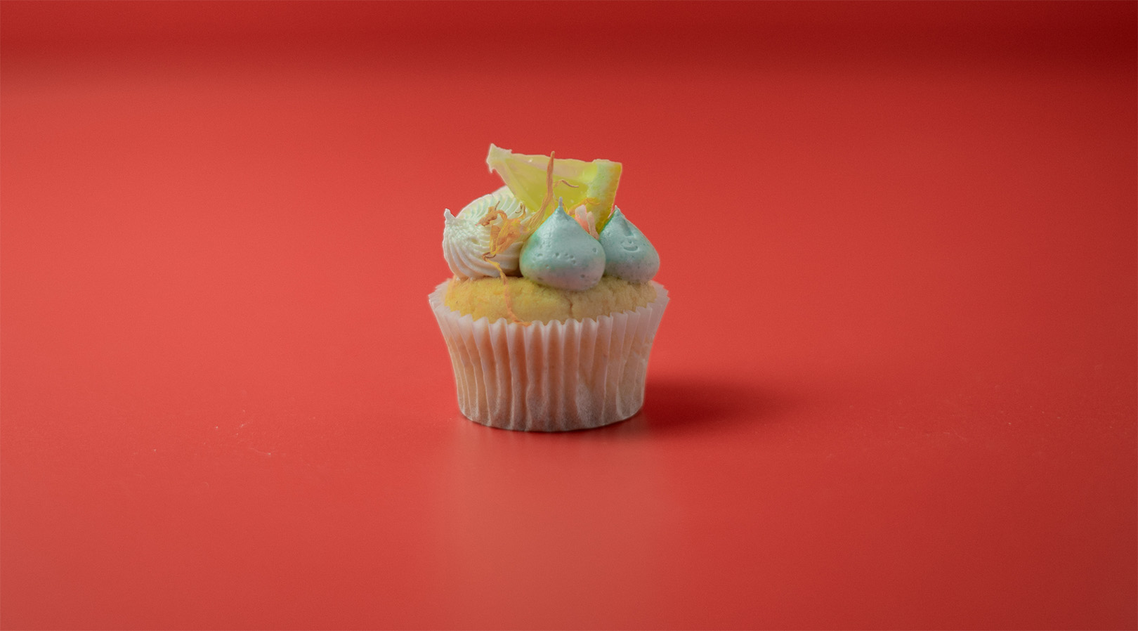 ein Cupcake mit Zuckerguss und Zitronenscheiben obenauf